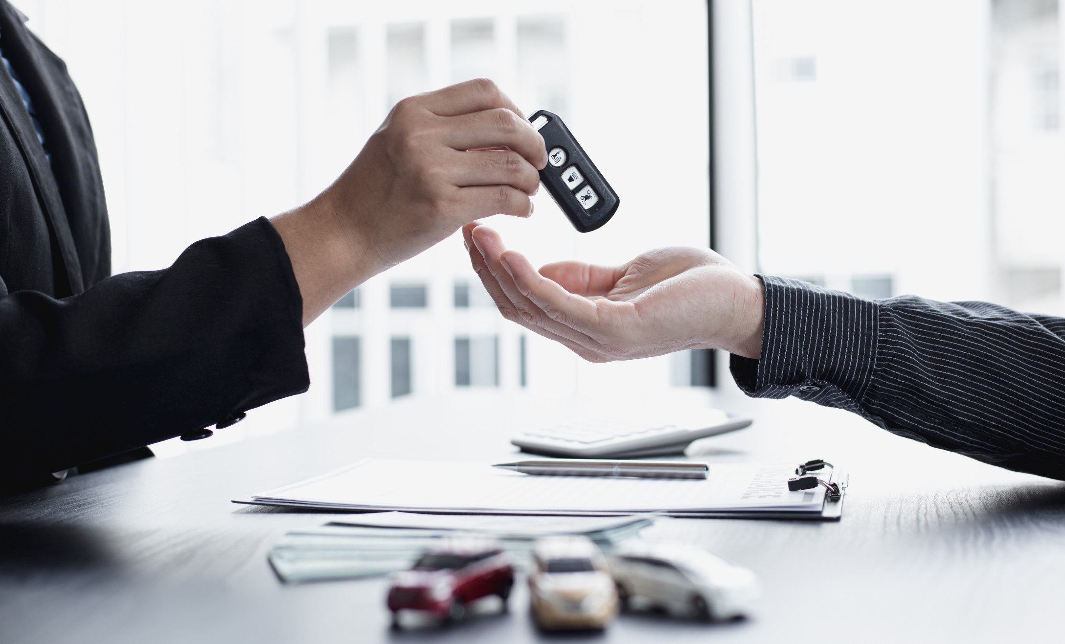 car-sales-representative-or-sales-manager-submits-a-car-key-to-a-client-who-has-approved-financial_t20_G0g97E